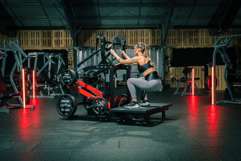 Kvinna tränar i Hammer Strength Belt Squat.